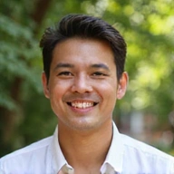 Smiling client A, a man in his 30s, standing in a natural, bright outdoor setting
